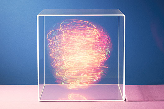 Colorful lights swirling around inside a clear box
