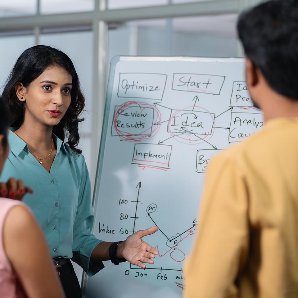 young girl at office discussing about project to team members or colleagues during meeting - concept of leadership presentation, workplace communication and startup culture.